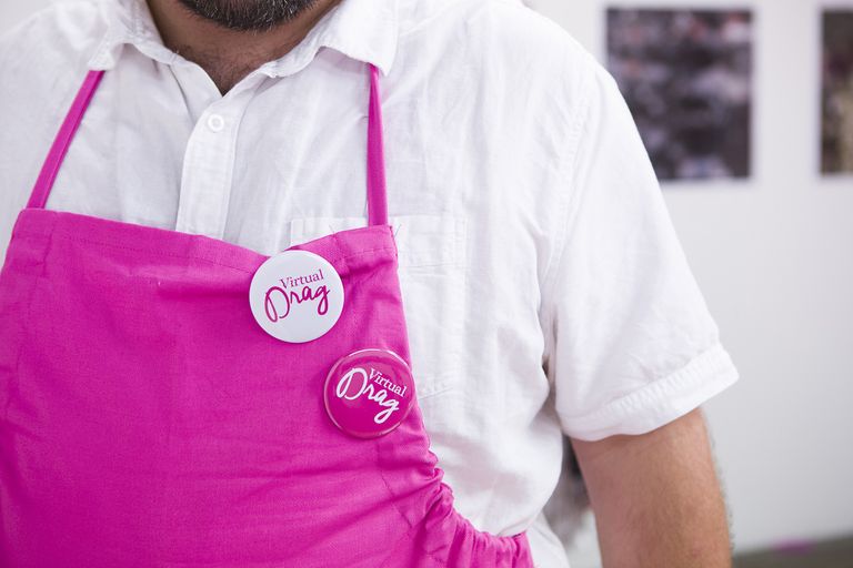 A pink apron worn by the Virtual Drag creators with a white badge that has the Virtual Drag logo